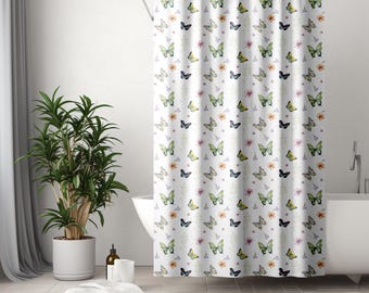 May include: White shower curtain with a repeating pattern of butterflies in shades of green, yellow, and blue, along with small floral accents. The curtain is hanging in a bathroom setting, creating a decorative and functional element.