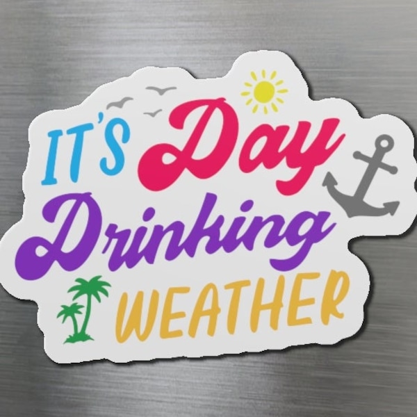 May include: A colorful magnet with the phrase "IT'S Day Drinking WEATHER" in a playful font. The design includes a sun, anchor, palm tree, and birds, suggesting a beach or vacation theme. The magnet is attached to a silver refrigerator.