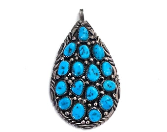 May include: A teardrop-shaped pendant with a silver setting and turquoise stones.