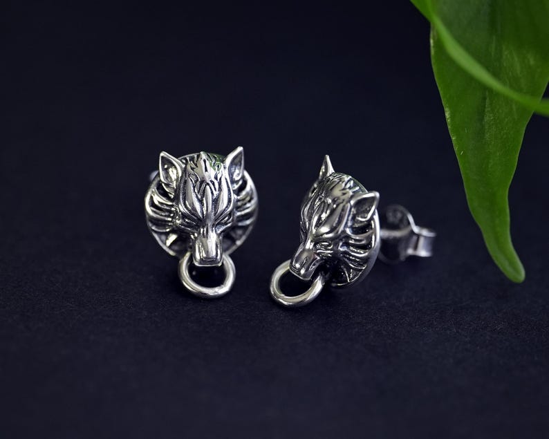 Puede incluir: Un par de pendientes de plata con un dise&ntilde;o de cabeza de lobo. La cabeza de lobo est&aacute; detallada con dientes afilados y una expresi&oacute;n feroz. Los pendientes son un accesorio &uacute;nico y elegante.