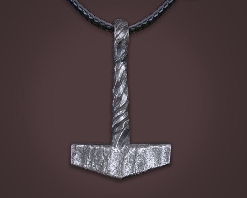 May include: A silver-colored Mjolnir pendant with a twisted rope design on the handle. The pendant is hanging from a black leather cord.