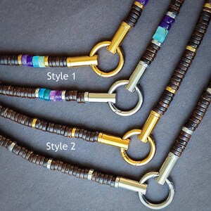May include: Three necklaces with brown wooden beads, gold and silver accents, and turquoise and purple gemstones. The necklaces are labeled "Style 1" and "Style 2".