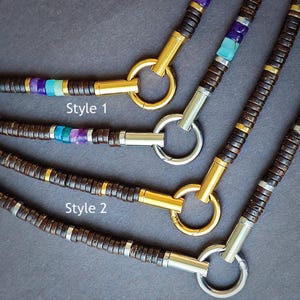 May include: Three necklaces with brown wooden beads, gold accents, and turquoise and purple gemstones. The necklaces have different styles, labeled "Style 1" and "Style 2".