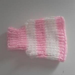 May include: A pink and white striped knitted turtleneck sweater for a small doll or stuffed animal.