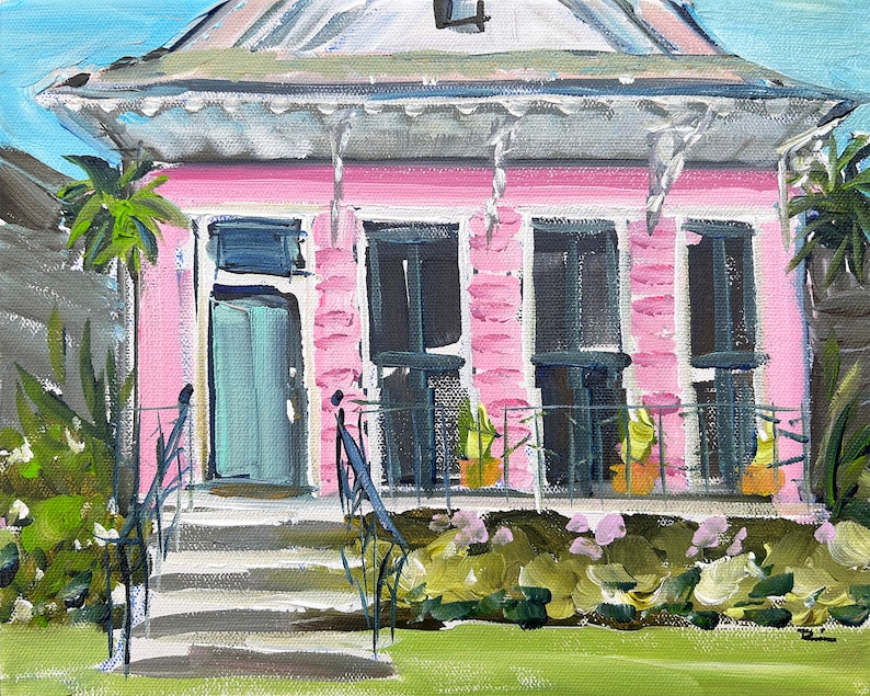 Puede incluir: Una casa rosa con un techo blanco y una puerta verde. La casa tiene un porche con barandillas negras y plantas en macetas. La casa est&aacute; rodeada de hierba verde y arbustos.