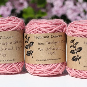 Può includere: Tre gomitoli di filato Cheviot filato a mano di colore rosa tinto con cocciniglia. Ogni gomitolo è etichettato "Highland Colours" e include informazioni sulla fibra, il colorante e il peso. Il filato pesa 2,5 g ciascuno.