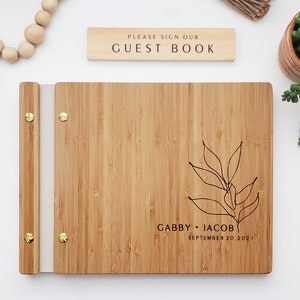 Engraved wooden wedding guest book in an amber finish with customized couples names and boho leaf design engraving.