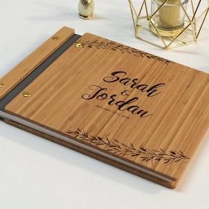 Engraved wooden guest book in an amber finish with customized couples names and boho leaf design engraving.