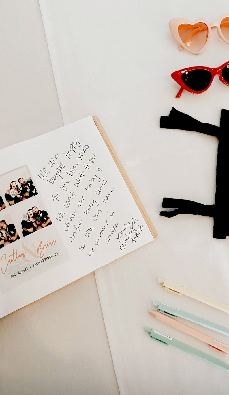 Archival quality cardstock paper allows for photos to be attached to the pages. Guest book shows an example of a photo booth print attached inside the book with guest message.