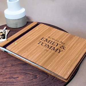 Customized wedding guest book featuring a minimalist engraved design sits on a small table.