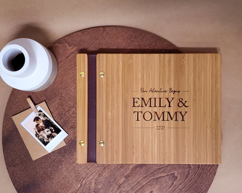 Customized, minimalist bamboo wedding guest book in an amber finish, featuring the couples first and last names and event date engraved in the cover.