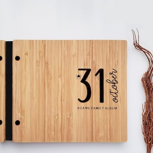 Custom wooden Halloween photo album in an amber finish, featuring a fun Halloween date and personalized text engraved on the cover.