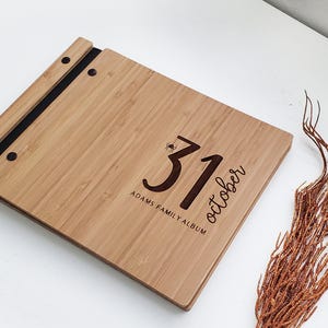 Personalized bamboo Halloween photo scrapbook album in an amber finish, customized with family names engraved on the cover.