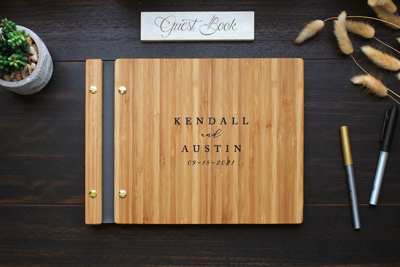 Custom wood wedding guest book in an amber finish, personalized with the bride and grooms names and event date engraved on the cover.