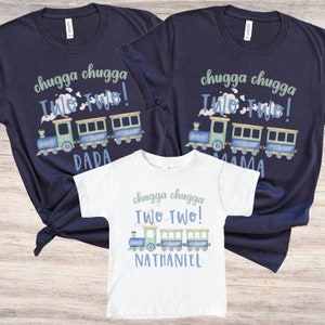 May include: Three t-shirts: two navy blue and one white. All feature a train graphic with the text "chugga chugga Two Two!" and names. The navy shirts say "DADA" and "MAMA". The white shirt says "NATHANIEL".