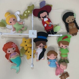 Pu&ograve; includere: Un mobile per bambini in feltro colorato con personaggi di famose storie per bambini, tra cui Peter Pan, Trilly, Capitan Uncino, Pocahontas e una sirena. Il mobile include anche due stelle gialle.
