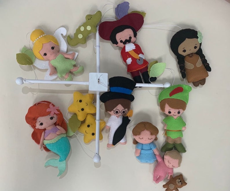 Pu&ograve; includere: Un mobile per bambini in feltro colorato con personaggi di famose storie per bambini, tra cui Peter Pan, Trilly, Capitan Uncino, Pocahontas e una sirena. Il mobile include anche due stelle gialle.