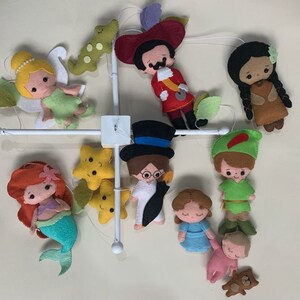 Pu&ograve; includere: Un mobile bianco con personaggi in feltro di film Disney. I personaggi includono Peter Pan, Trilly, Capitan Uncino, Pocahontas, Ariel, Alice nel Paese delle Meraviglie e un bambino con un orsacchiotto. Ci sono anche due stelle gialle.