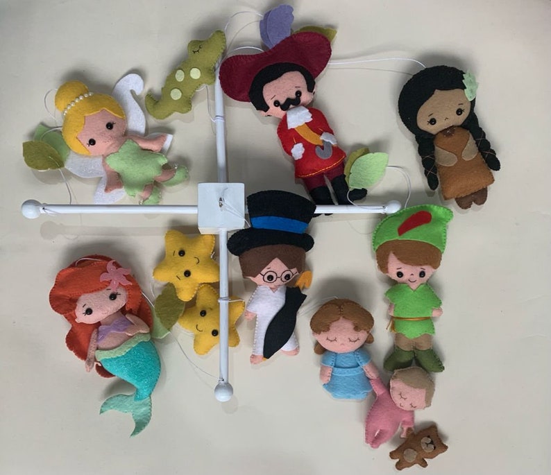 Pu&ograve; includere: Un mobile bianco con personaggi in feltro di film Disney. I personaggi includono Peter Pan, Trilly, Capitan Uncino, Pocahontas, Ariel, Alice nel Paese delle Meraviglie e un bambino con un orsacchiotto. Ci sono anche due stelle gialle.