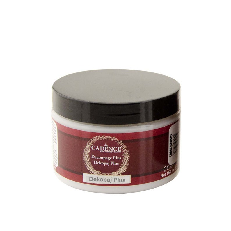 May include: A white jar of Cadence Decoupage Plus decoupage medium. The jar has a black lid and a red label with gold lettering. The label says "Cadence Art & Hobby Paints Decoupage Plus Dekopaj Plus Dekopaj Plus".