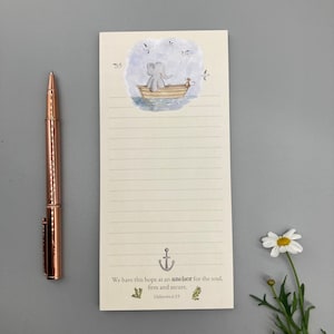 Op de afbeelding: Een notitieblok met een gelinieerd blad en een schattige illustratie van een olifant in een boot met vogels die erboven vliegen. Het notitieblok heeft een citaat uit Hebreeën 6:19, "We hebben deze hoop als een anker voor de ziel, vast en zeker."