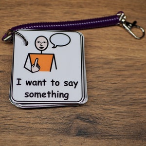 May include: A white card with a black and orange stick figure with a speech bubble. The text on the card reads "I want to say something".
