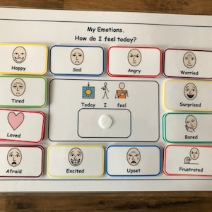 May include: A white board with the title "My Emotions. How do I feel today?" and a grid of 12 colorful squares, each containing a different facial expression. The squares are labeled with words describing emotions, such as "Happy", "Sad", "Angry", "Worried", "Tired", "Loved", "Afraid", "Excited", "Upset", "Frustrated", "Surprised", and "Bored".