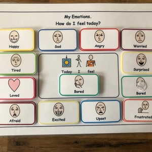 May include: A white board with colorful squares containing different facial expressions. The text "My Emotions. How do I feel today?" is at the top of the board. The squares contain images of happy, sad, angry, worried, tired, surprised, loved, bored, afraid, excited, upset, and frustrated.