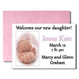 May include: A white card with a pink envelope announcing the birth of a baby girl named Jenna Kate. The card includes the baby's birthdate, weight, and the parents' names: Marcy and Glenn Graham.