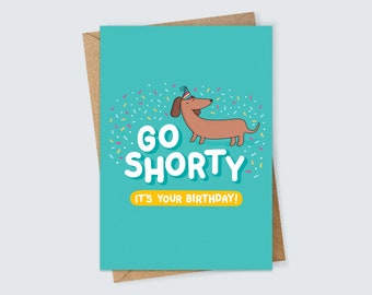 May include: A turquoise blue birthday card with a cartoon dachshund wearing a party hat. The card says "Go Shorty It's Your Birthday!" with confetti in the background.