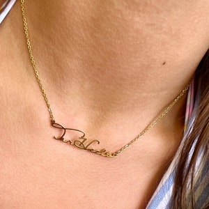 May include: A gold chain necklace with a cursive name pendant that says "Theresa".