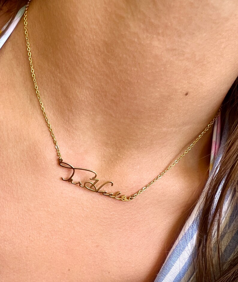 May include: A gold chain necklace with a cursive name pendant that says "Theresa".