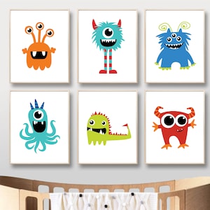 May include: Six framed art prints featuring colorful cartoon monsters. Each monster has a unique design, with varying colors, shapes, and features. The prints are displayed above a wooden crib.