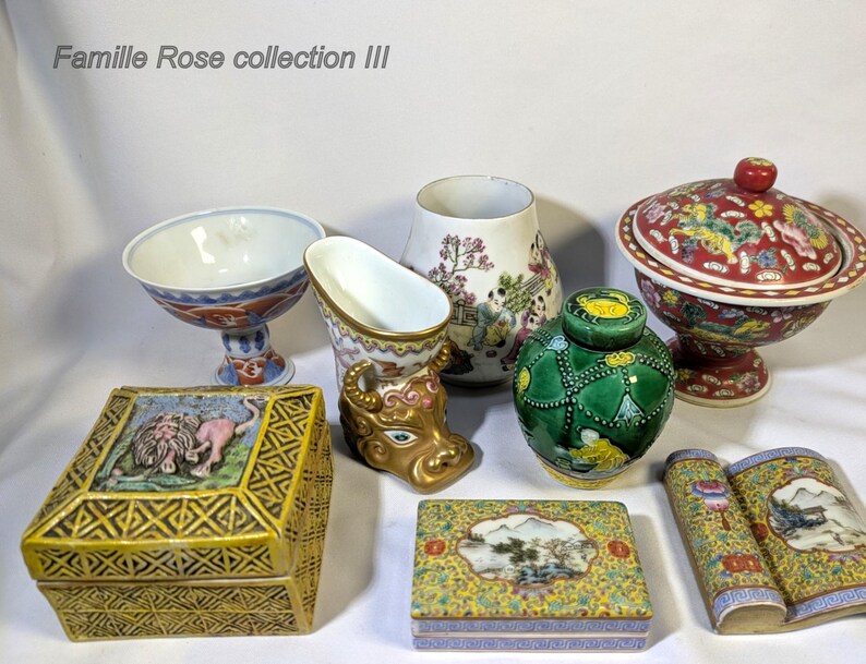 Op de afbeelding: Een verzameling antieke Chinese porseleinen items, waaronder een kom met deksel, een vaas, een kleine pot en twee decoratieve dozen. De items hebben ingewikkelde bloemen- en landschapsontwerpen in rood, groen, geel en blauw.