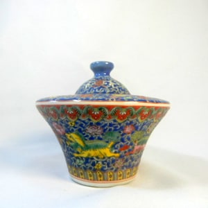 May include: A blue and white porcelain lidded jar with a floral and dragon design. The jar has a wide base and a narrow neck. The lid is decorated with a floral design.