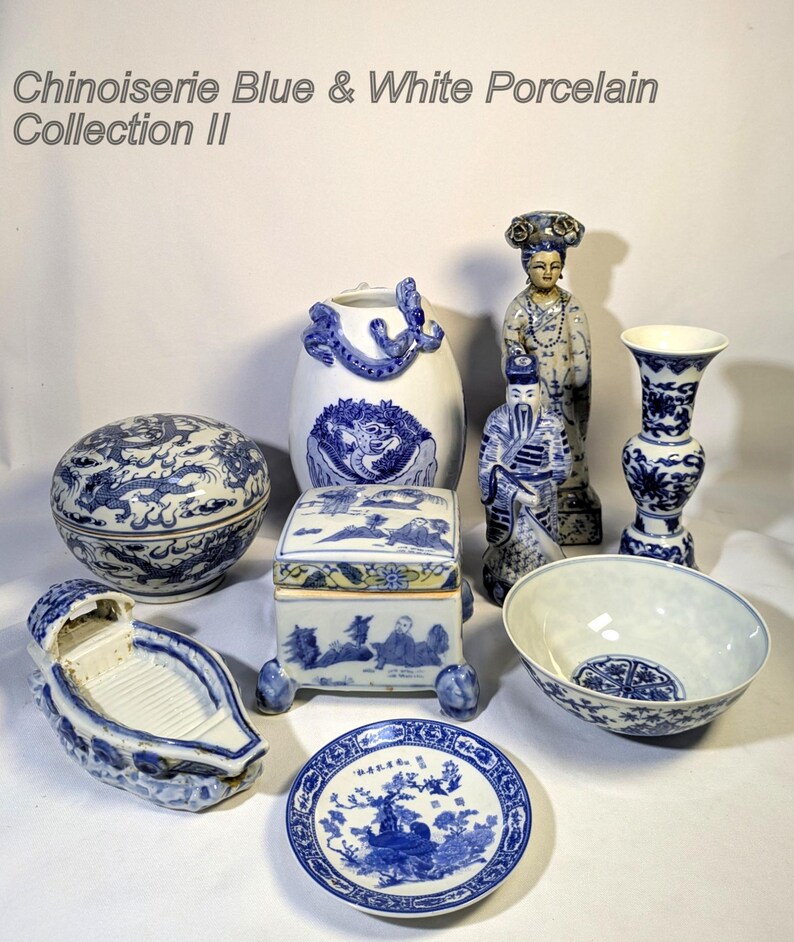 Op de afbeelding: Een verzameling blauw-witte porseleinen items, waaronder een ronde doos met deksel, een bootvormige schaal, een klein bord, een vaas, een kom en een decoratieve doos. De items hebben ingewikkelde ontwerpen en figuren. De tekst "Chinoiserie Blue & White Porcelain Collection II" staat bovenaan.