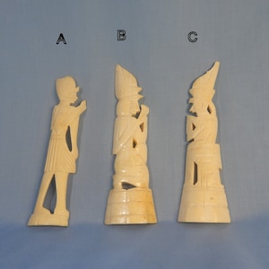 Puede incluir: Tres tallas de marfil de figuras en diferentes poses. Las figuras est&aacute;n todas de pie y tienen detalles intrincados. Las tallas est&aacute;n etiquetadas como A, B y C.