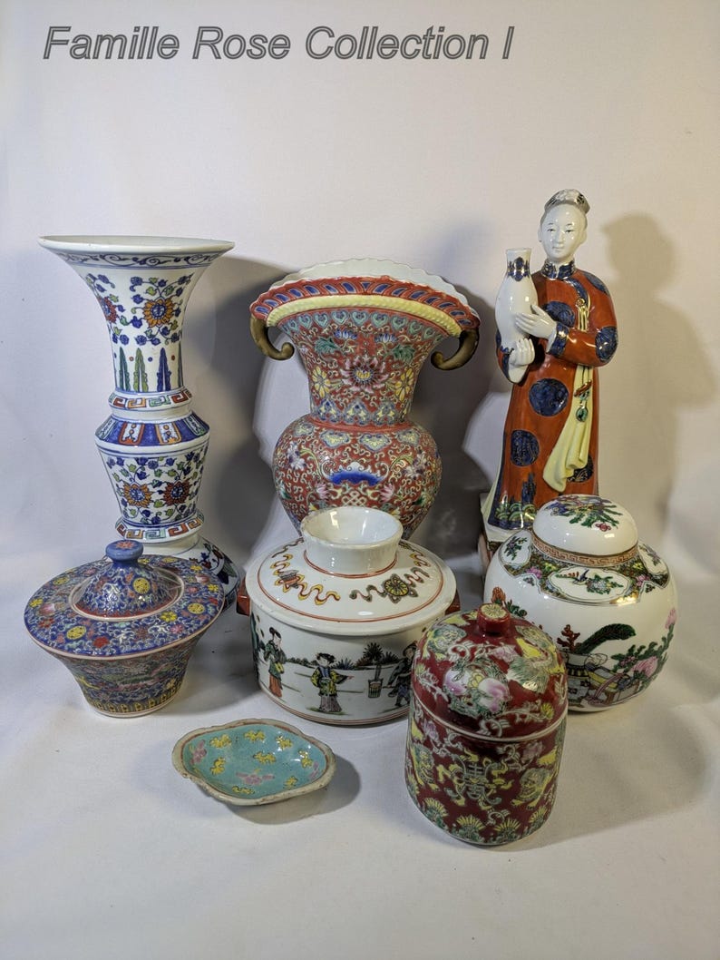 Op de afbeelding: Een verzameling Famille Rose porseleinen items, waaronder vazen, potten met deksel en een beeldje. De stukken hebben ingewikkelde bloemen- en figuurontwerpen in rood, blauw en goud. De tekst "Famille Rose Collection I" staat bovenaan.