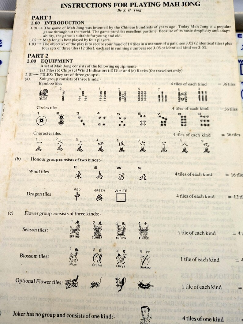 May include: An open book with instructions for playing Mah Jong. The text includes an introduction, equipment list, and details on tiles, including Bamboo, Circles, Character, Wind, Dragon, Flower, and Blossom tiles.