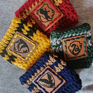 Puede incluir: Cinco coloridas fundas de ganchillo para bebidas. Cada funda presenta una combinaci&oacute;n de colores diferente: rojo y dorado, amarillo y negro, verde y plateado, y azul y beige. Cada funda tiene un parche de cuero con un gr&aacute;fico negro.