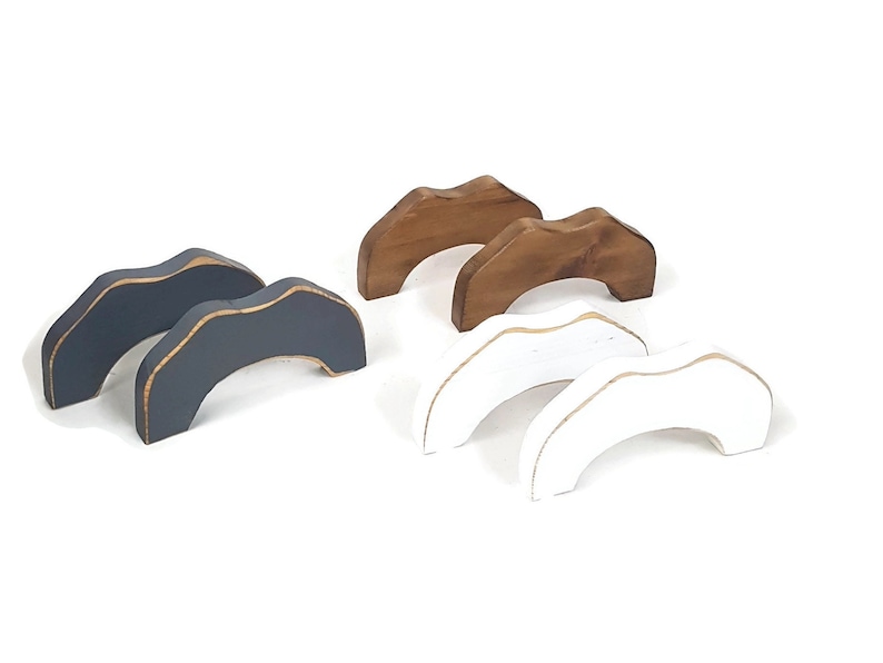 May include: Set of six wooden arches in three colors: gray, brown, and white. The arches are painted and have a gold accent around the top edge.