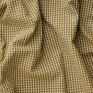 May include: A fabric featuring a small-scale gingham check pattern in mustard yellow and dark charcoal grey. The textile displays a textured, slightly crinkled surface with deep folds and gathers that create a dynamic play of light and shadow.