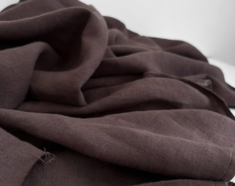 May include: Close-up of a dark brown linen fabric, with visible texture and folds. The fabric is draped, creating shadows and depth. The color is a rich, earthy tone, suitable for various textile projects.