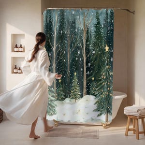 May include: A forest-themed shower curtain with a winter scene. The design features tall evergreen trees, falling snowflakes, and a snowy ground. The curtain is hanging in a bathroom with a white bathtub and a wooden stool.