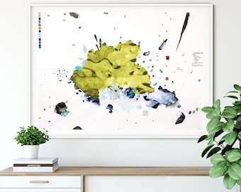 Op de afbeelding: Abstracte kunstprint met een grote gele en groene vorm in het midden, omringd door kleinere blauwe, zwarte en rode vormen. De print is ingelijst in een wit frame en hangt aan een witte muur.