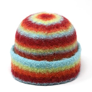 May include: A colorful striped knit hat with red, orange, yellow, blue, and green stripes. The hat is made of a soft, fuzzy material.
