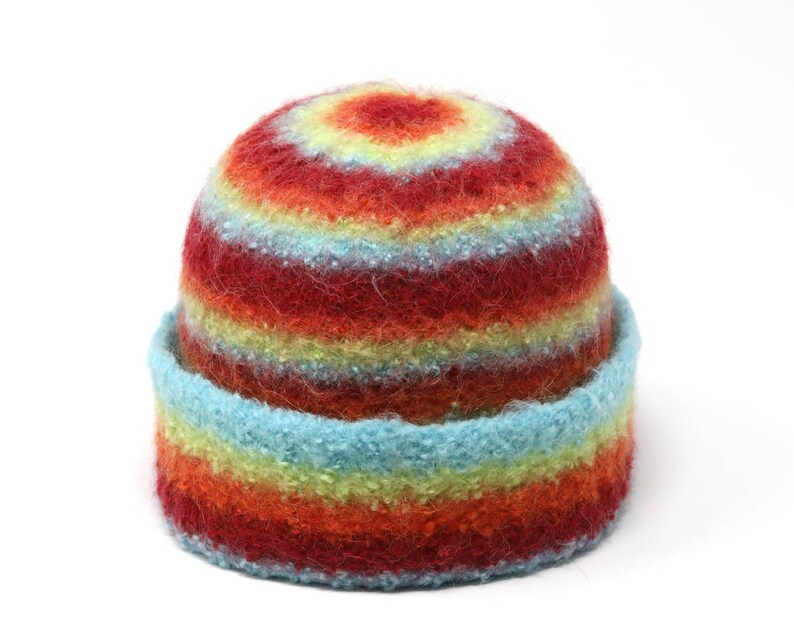 May include: A colorful striped knit hat with red, orange, yellow, blue, and green stripes. The hat is made of a soft, fuzzy material.