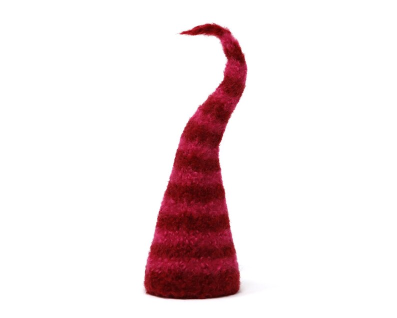 May include: A red felt gnome hat with white stripes. The hat is pointed and has a curled brim.