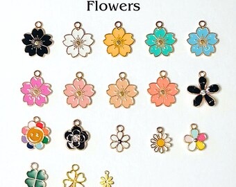 May include: A collection of colorful flower charms in various designs and sizes. The charms include black, white, yellow, teal, pink, orange, and blue flowers, as well as a four-leaf clover and a daisy. The word "Flowers" is printed at the top.
