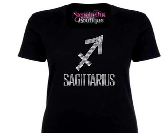 May include: Black t-shirt with a white rhinestone Sagittarius zodiac sign and the word "SAGITTARIUS" in rhinestones.